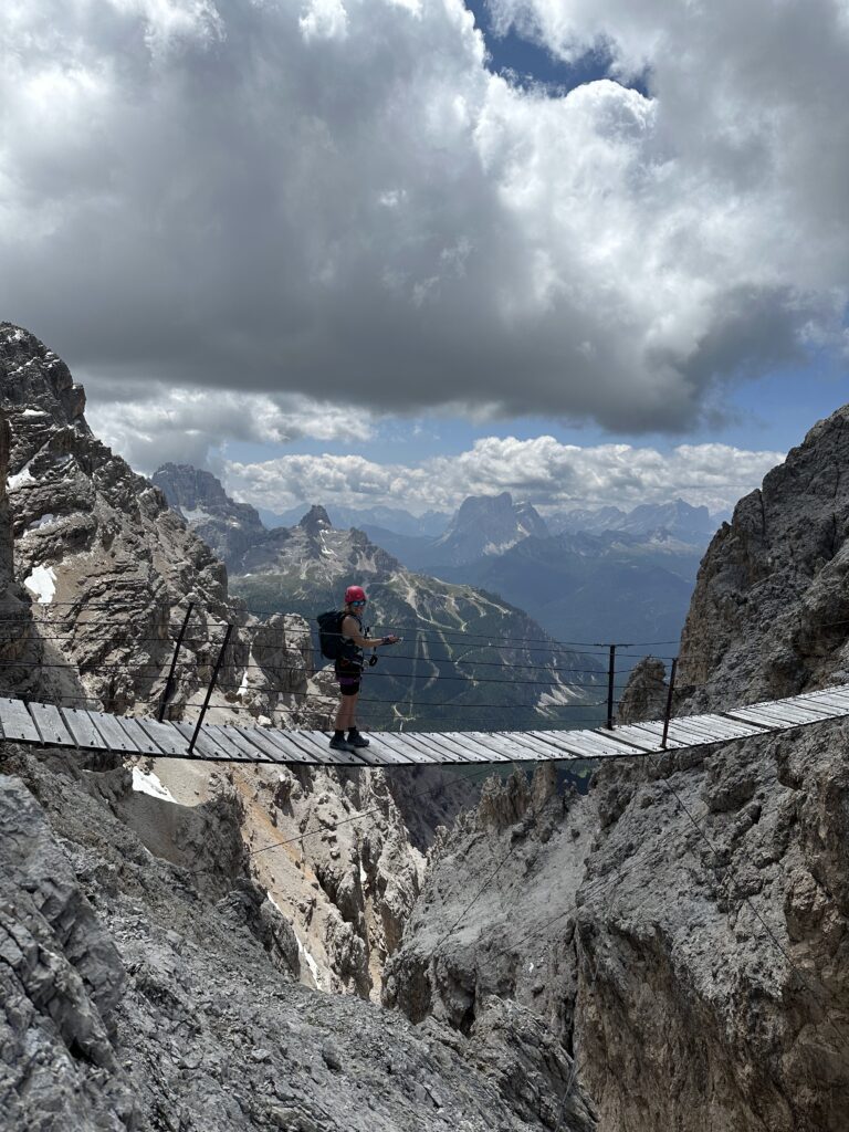 Kabantis Ponte Critallo tiltas kalnuose su per juo einančia mergina