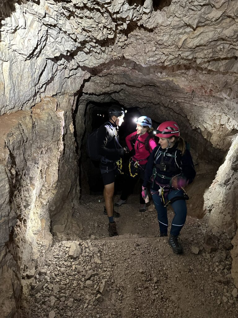 Via Ferrata de Luca – Innerkofler maršruto tuneliuose stovintys žmonės su šalmais ir ciklopais