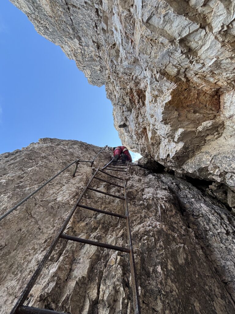 Kopėčiomis lipanti mergina į Torri di Toblin viršūnę