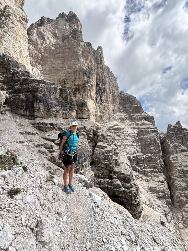 Moteris stovinti ant atbrailos via ferrata Croda Dei Toni maršrute, Monte Popera Circuit, Dolomituose