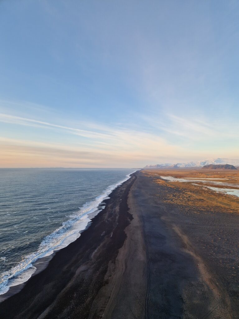 Nesibaigiantis juodos smėlio paplūdimys Dyrhólaey Beach Islandijoje