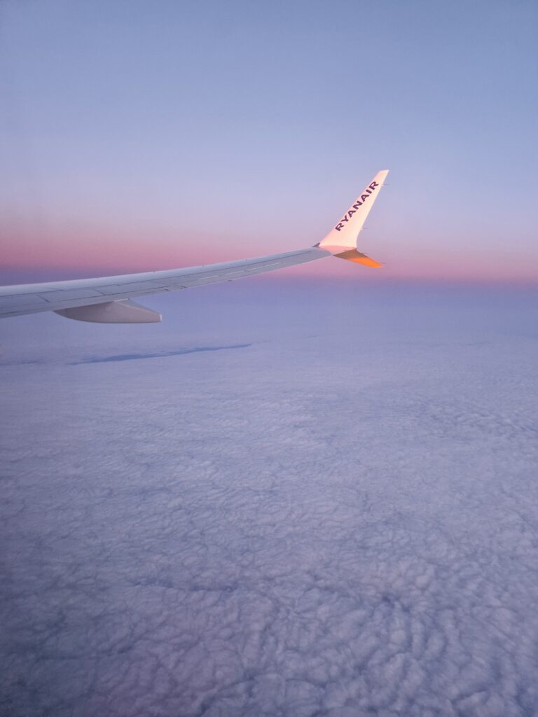 Saulėlydis danguje pro lėktuvo langą