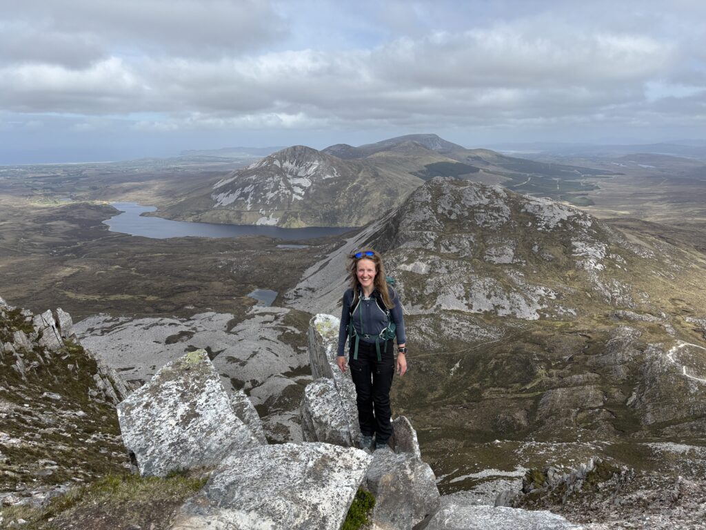 Lankytinos vietos Airijoje: Moteris, pozuojanti ant tako, vendačio į Errigal kalno viršūnę Airijoje
