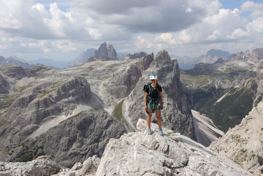 Moteris su via ferrata įranga Via ferrata Strada degli Alpini maršrute, Italijos Dolomituose, su vaizdais į Tre Cime di Lavaredo